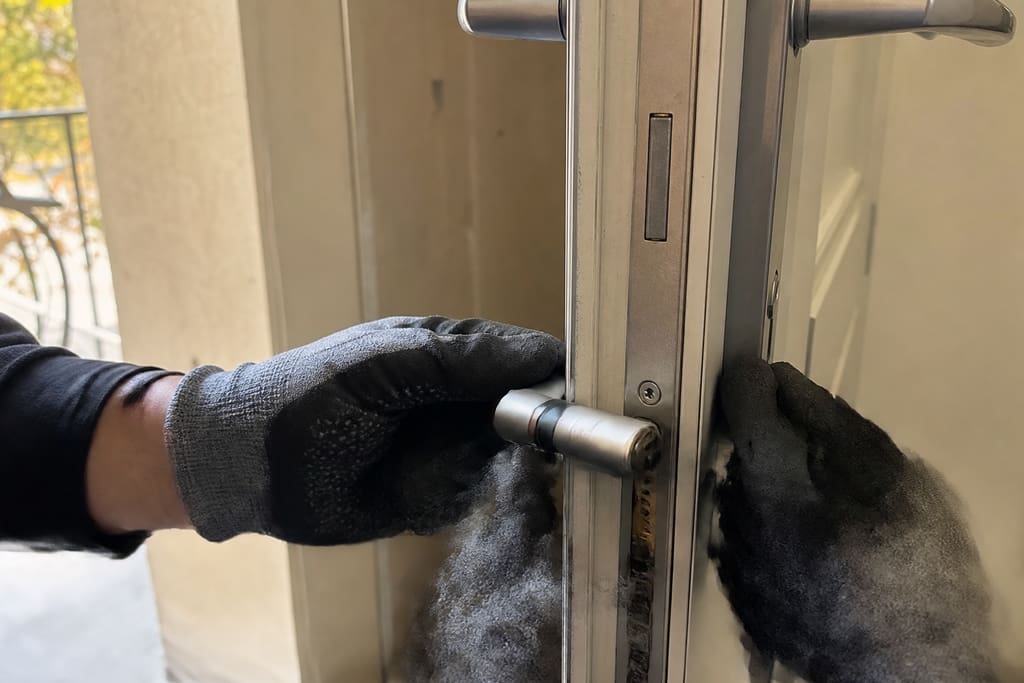 mains remplaçant cylindre de porte d'entrée en gros plan