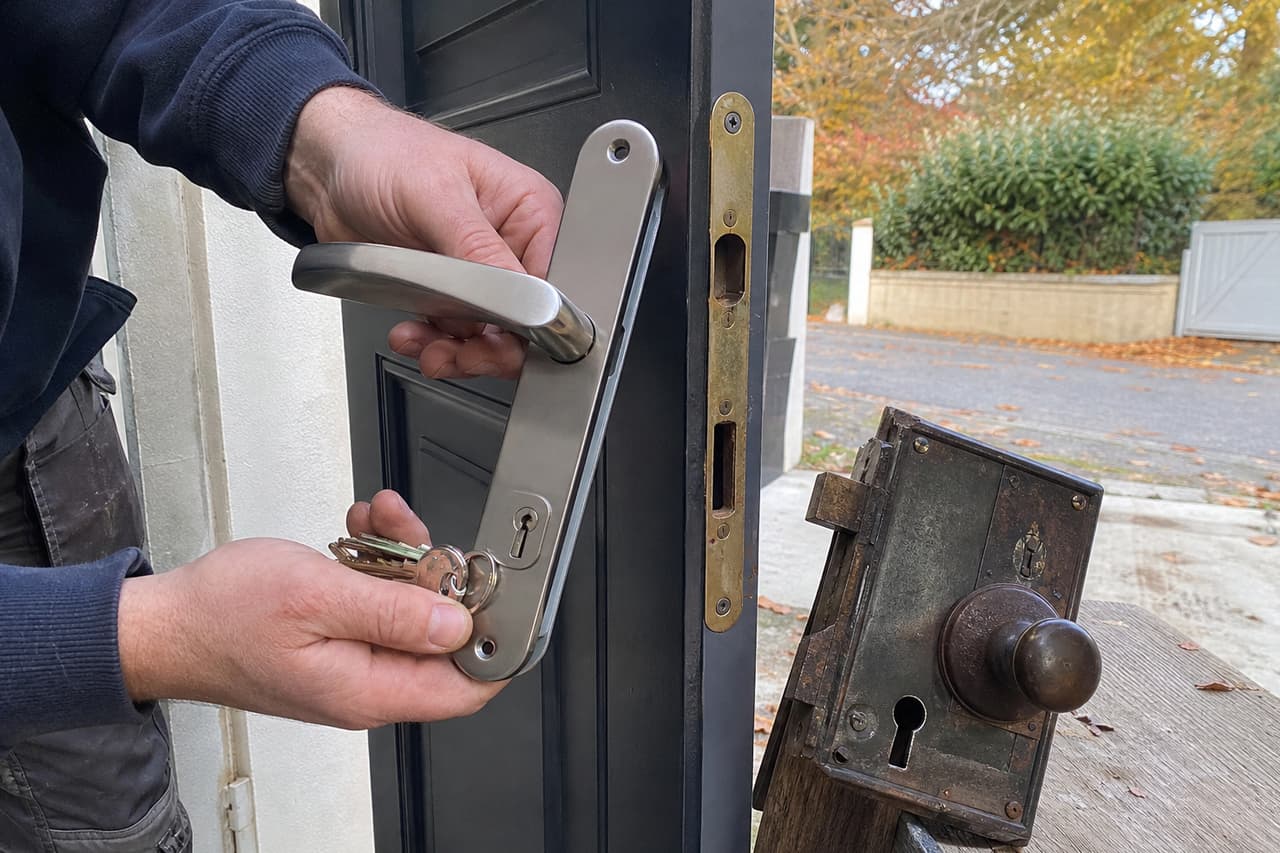 mains tenant nouvelle serrure et clés, ancien mécanisme posé